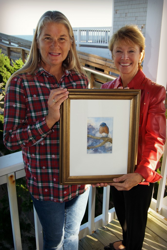 Holly Robinson, N.E.S.T. Board member (right) presents Kim Stoltz, as the proud winner of the 2015 art raffle "Between Heaven and Earth" by E.M. Corsa.