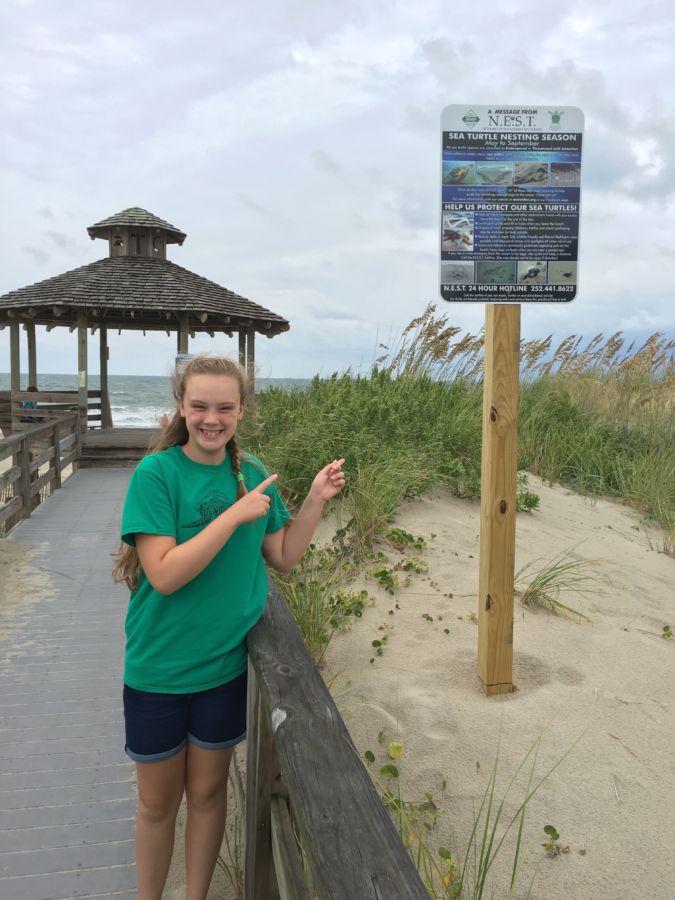 Ellen points out the NEST educational sign